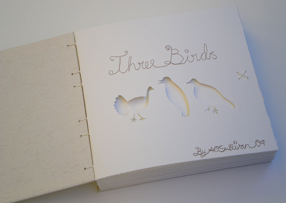 Opening title page of the Three Birds Book with stitching and cutouts