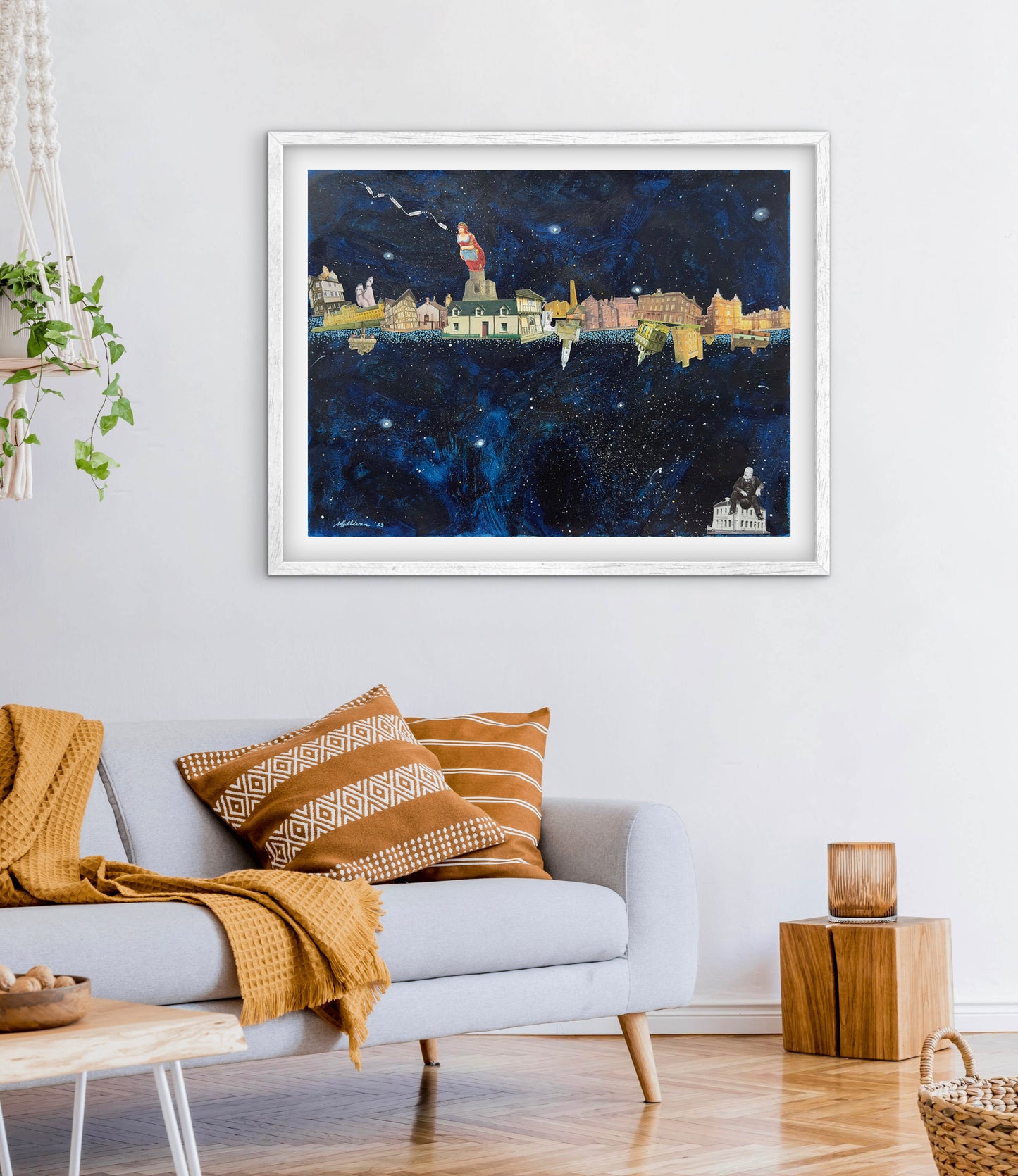 Framed artwork of a cityscape on a wall above a sofa with decorative pillows.