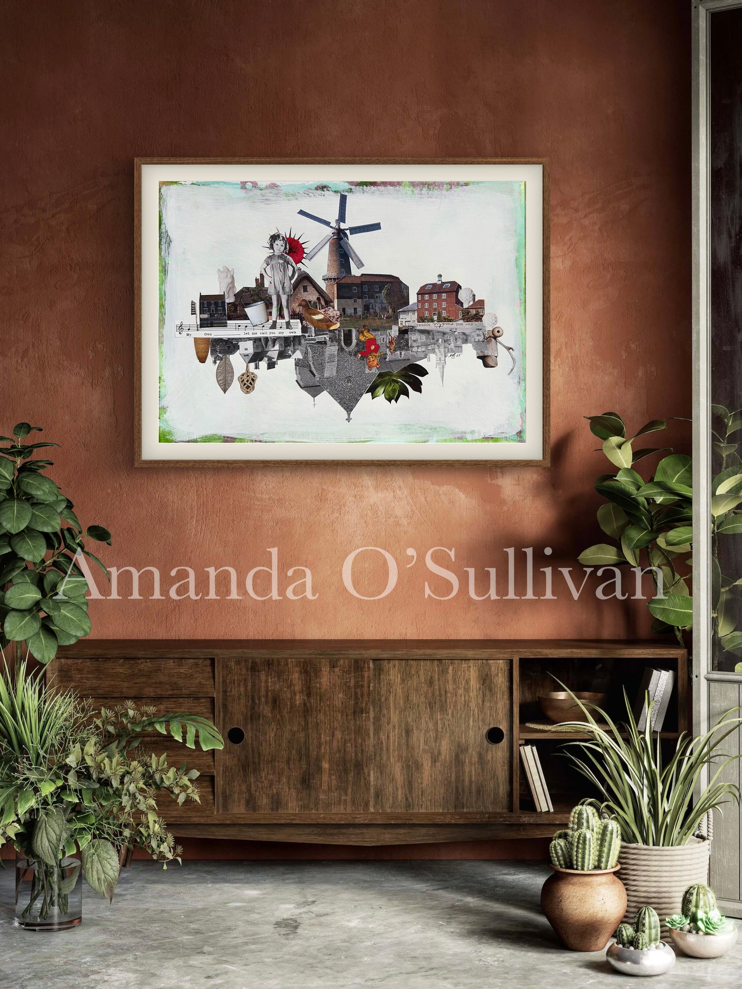 Framed artwork on a wall with plants and a wooden cabinet below.