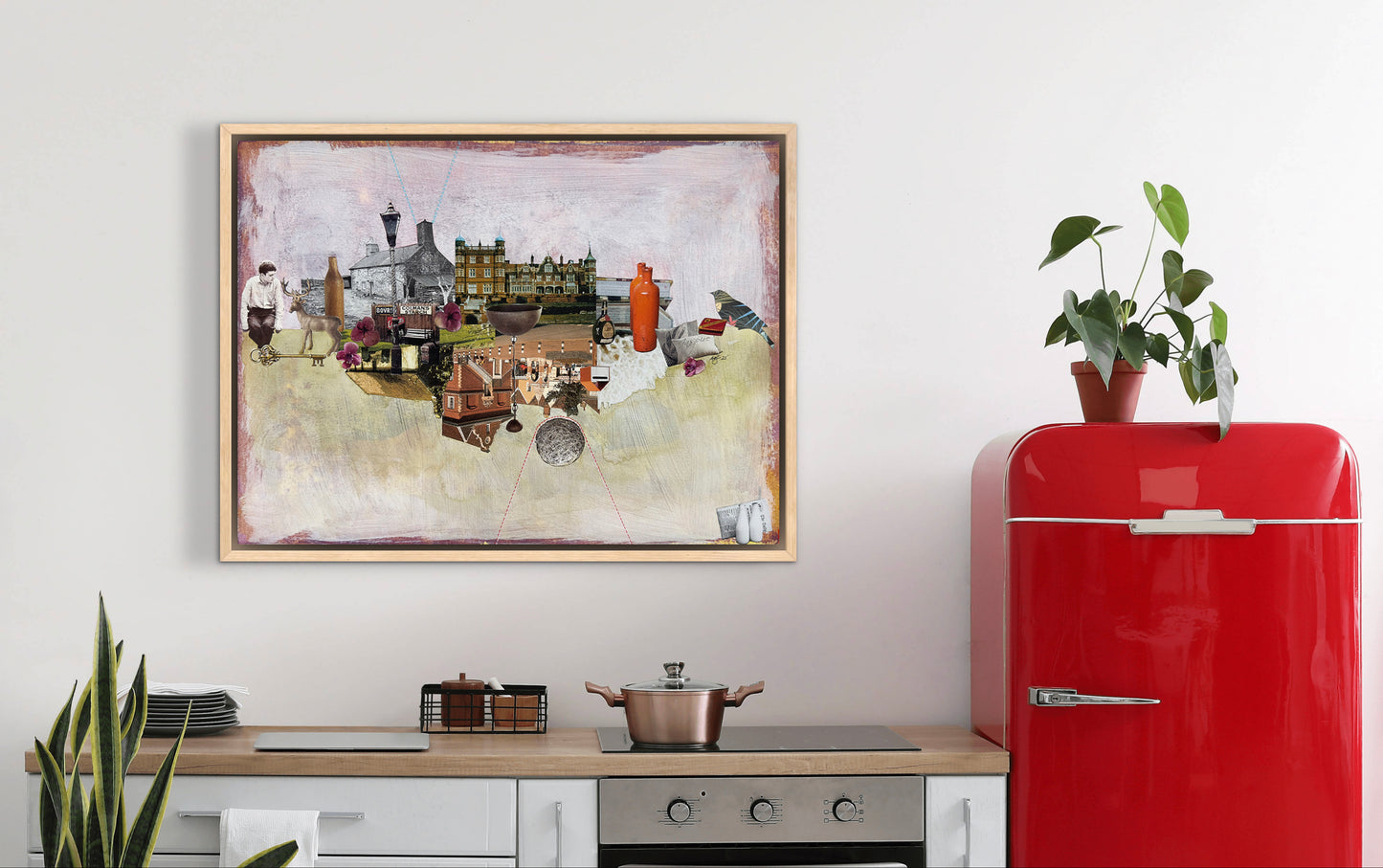 Red refrigerator next to a wall with a framed picture and a plant on a white wall.