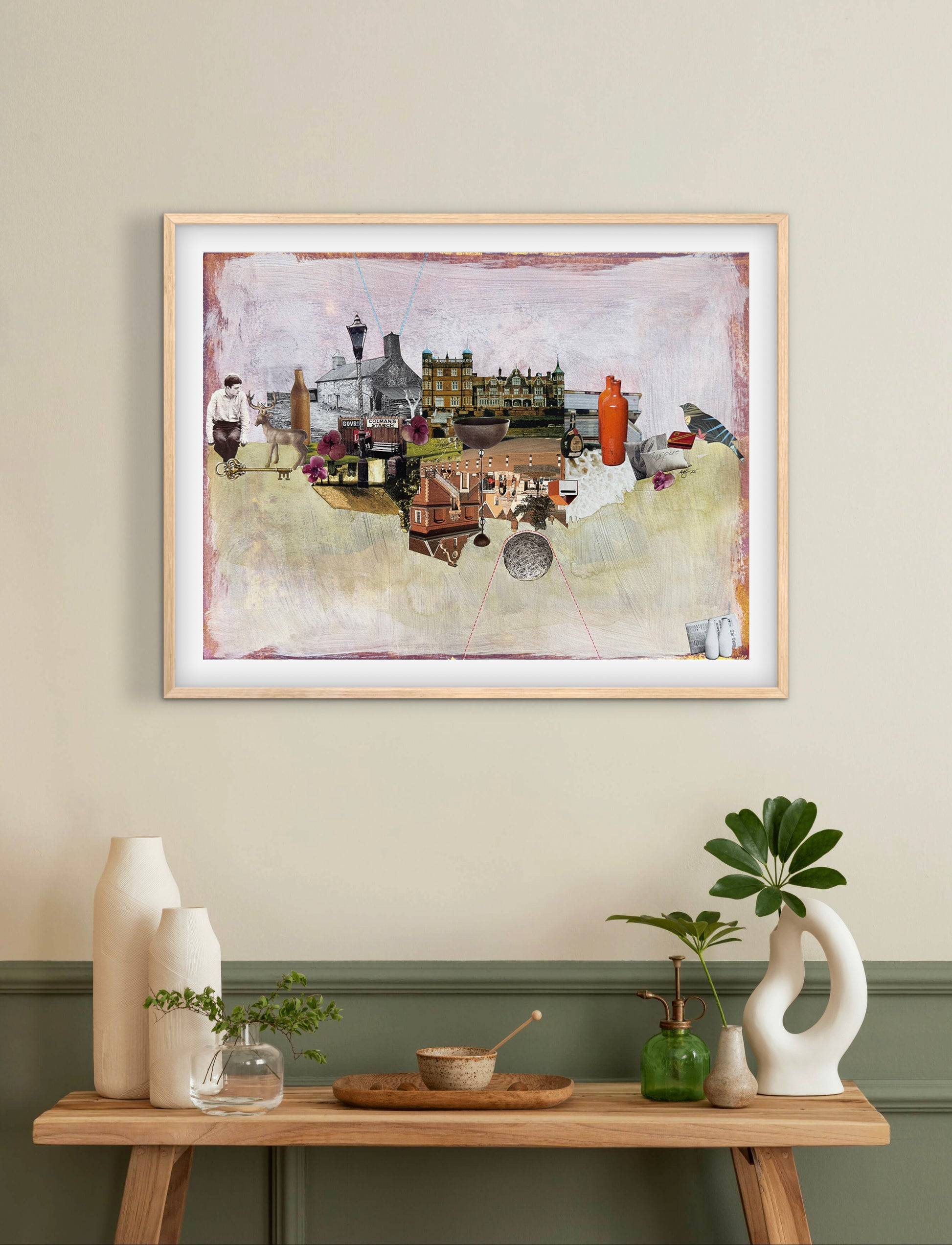 Framed artwork on a wall above a wooden table with decorative items.