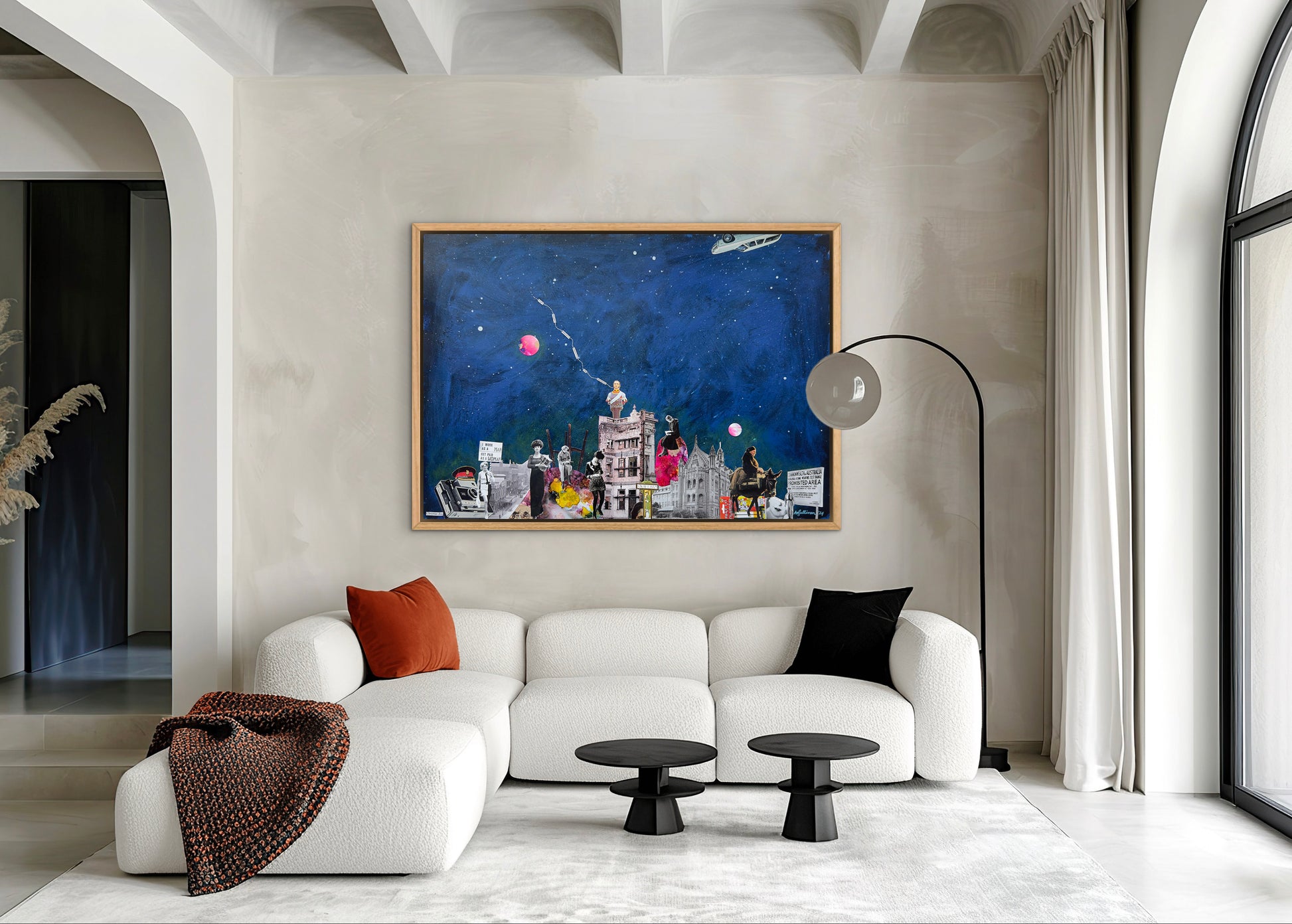 Modern living room with a white sofa, colorful painting, and decorative pillows.