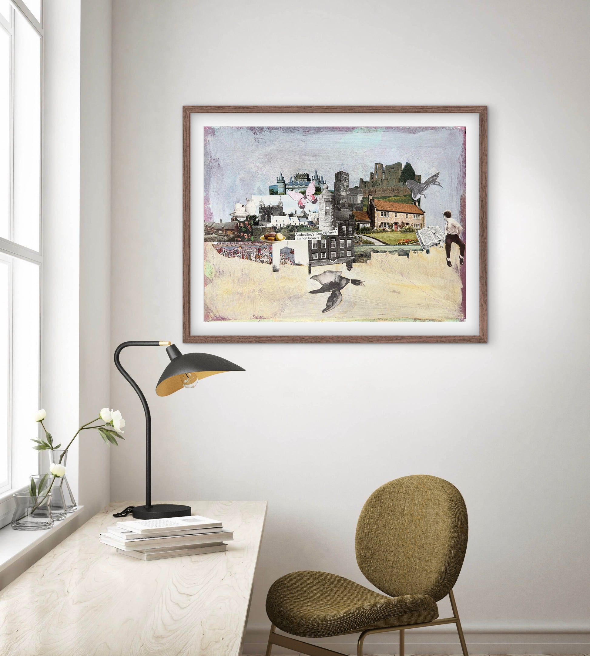 Framed artwork of a cityscape with people on a wall above a desk with a lamp and chair.