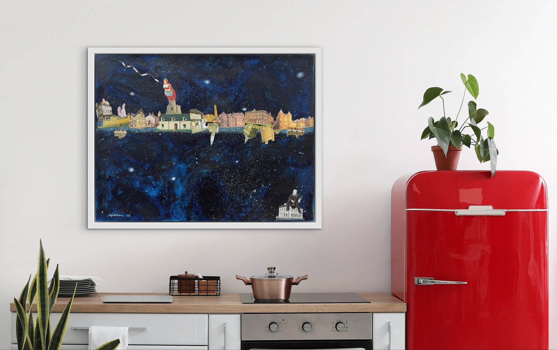 Red refrigerator next to a framed cityscape painting on a white wall.