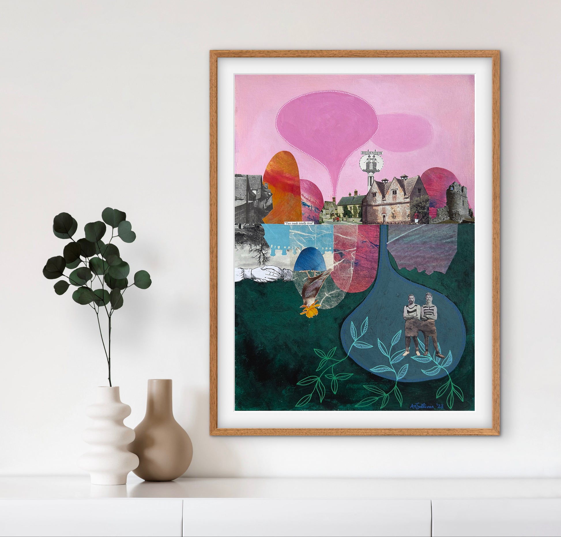 Framed abstract artwork with colorful elements on a white wall.