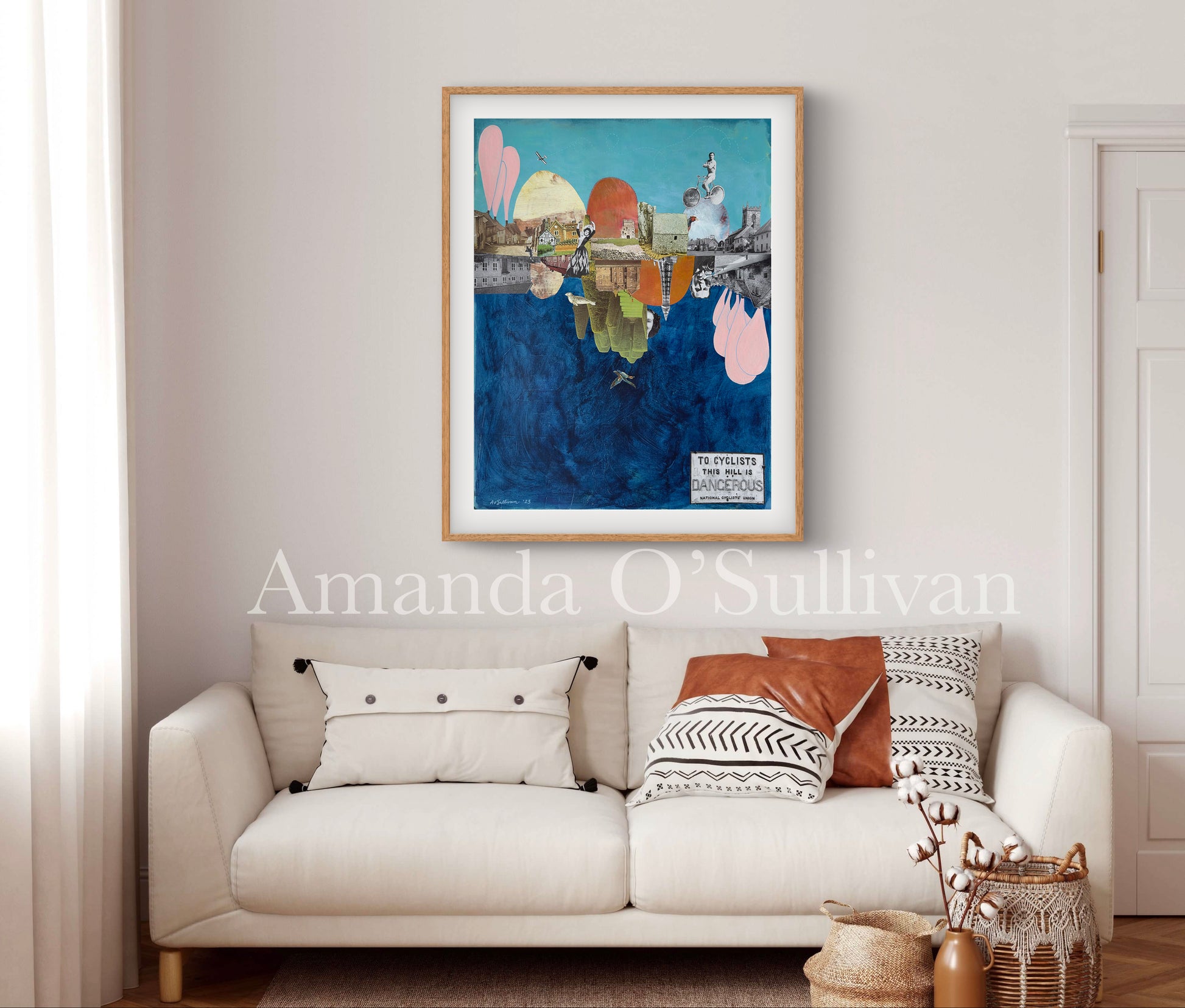 Framed artwork above a sofa with decorative pillows in a living room setting.